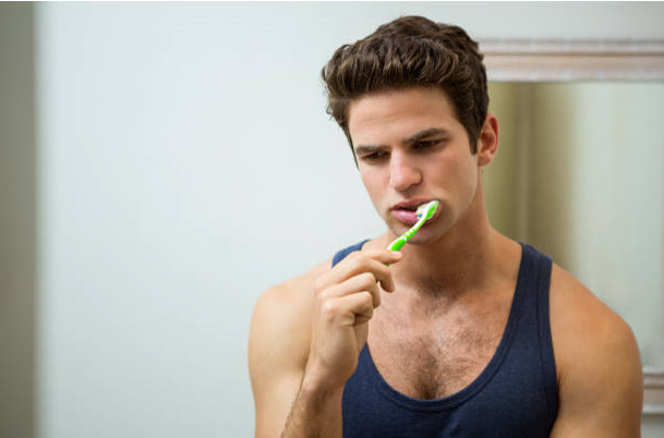 Young man brushing his teeth in bathroom Young man brushing his teeth in bathroom at home brushing teeth too hard stock pictures, royalty-free photos & images